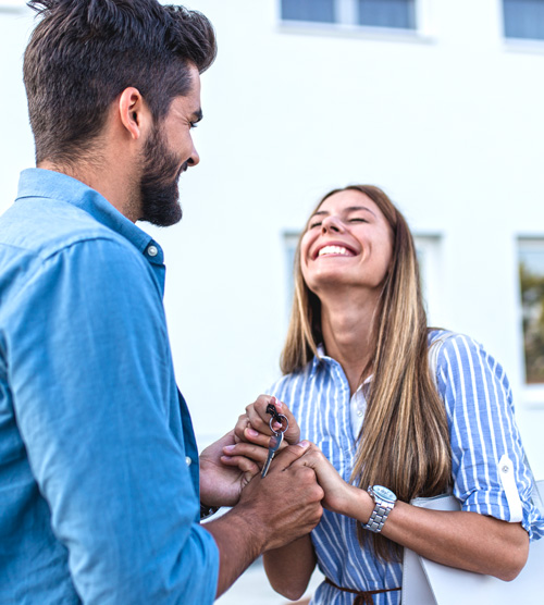 jeune couple heureux avec les clefs de leur 1er appartement